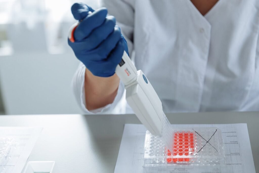 Close-up of a scientist using a pipette in a lab with a focus on sterile procedures.